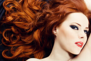 Junge Frau passend zum roten Haar geschminkt
