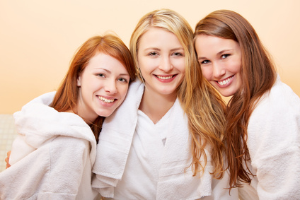 Drei lachende Frauen im Bad im Bademantel