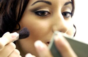 Eine junge Frau trägt Make-Up auf
